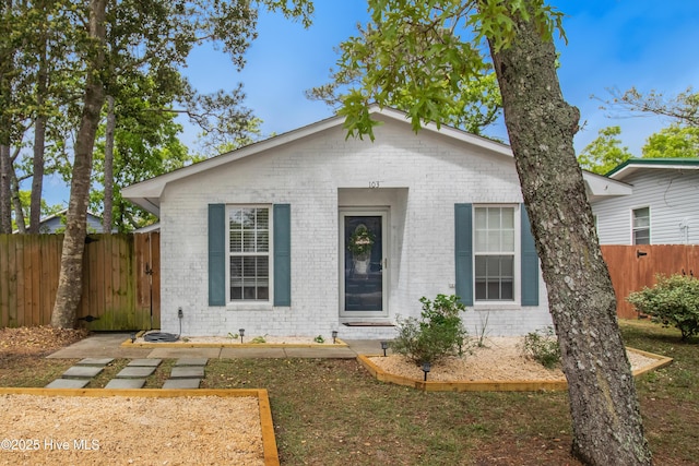 bungalow with brick siding and fence