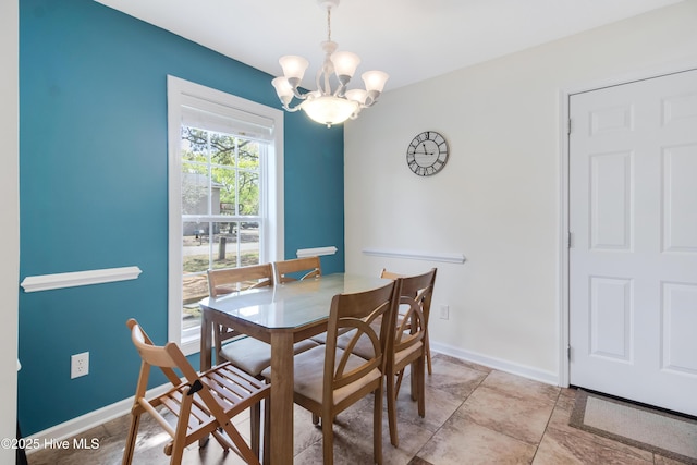 dining space featuring an inviting chandelier and baseboards