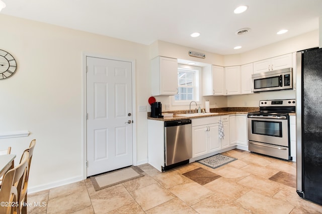 kitchen featuring visible vents, white cabinets, appliances with stainless steel finishes, and a sink