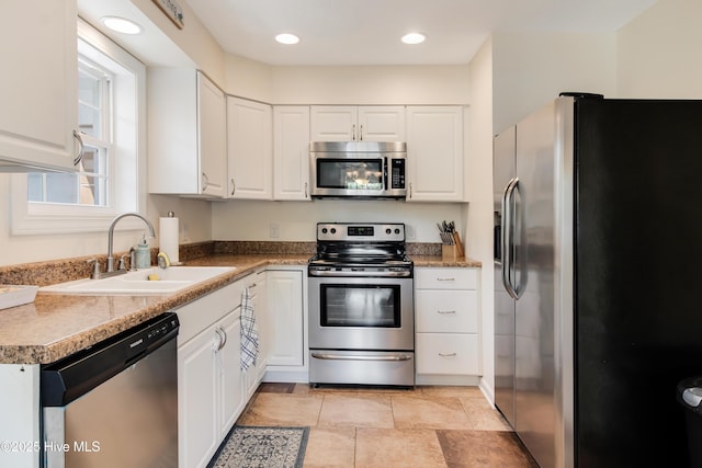 kitchen with a sink, white cabinets, recessed lighting, and stainless steel appliances