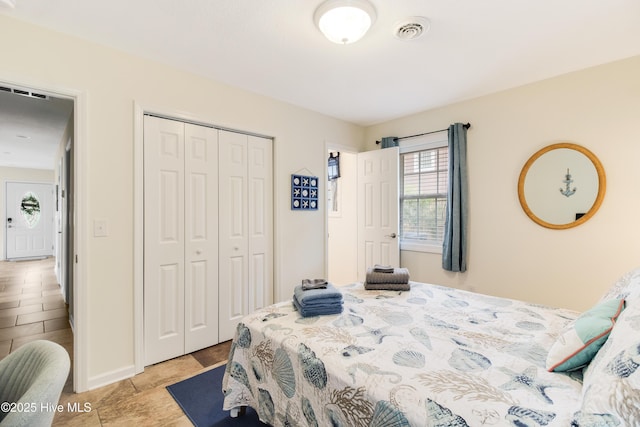 bedroom with a closet, visible vents, and baseboards