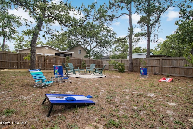 view of yard with a fire pit, a fenced backyard, and a patio area