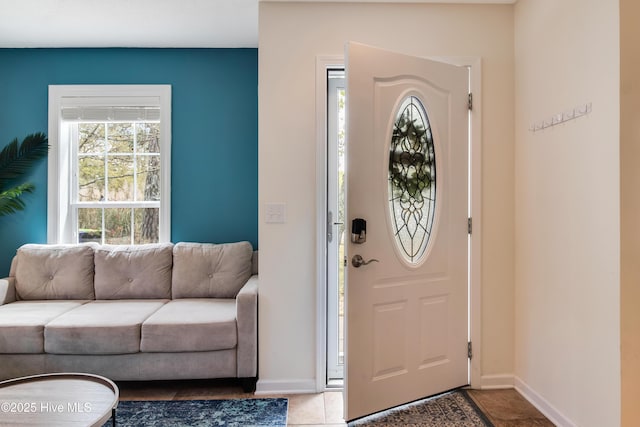 foyer entrance with tile patterned floors and baseboards