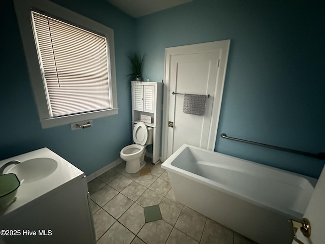 bathroom with a tub, tile patterned flooring, toilet, and vanity