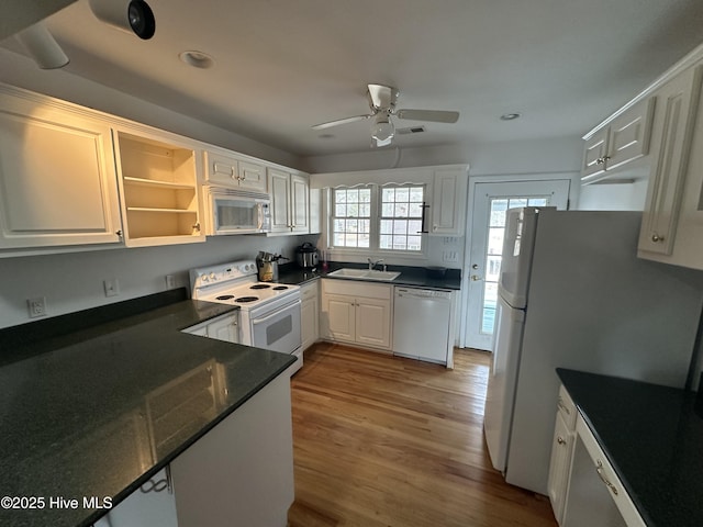 kitchen with sink, white appliances, white cabinets, and light wood-type flooring