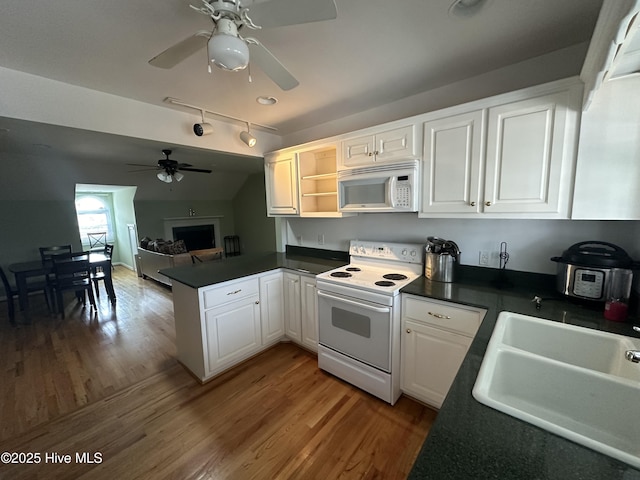 kitchen featuring kitchen peninsula, hardwood / wood-style floors, sink, white appliances, and white cabinets