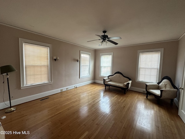 living area featuring light hardwood / wood-style floors, ceiling fan, and ornamental molding