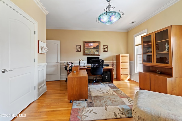 office area featuring crown molding, light wood-style floors, and a wainscoted wall