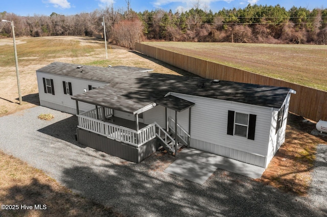 view of front of property with fence, a deck, and a front lawn