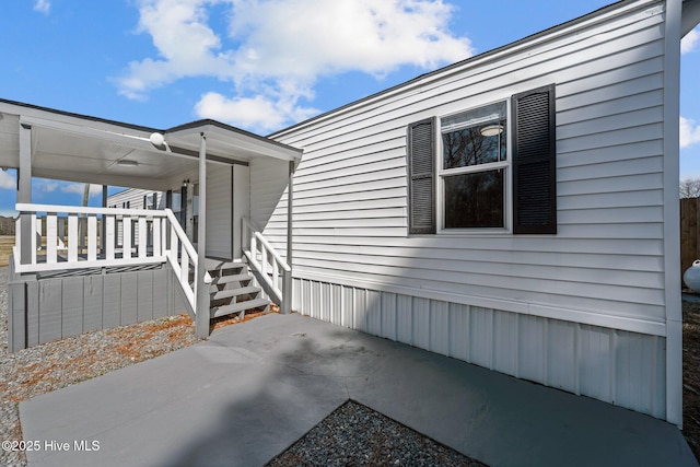 view of property exterior featuring a porch and a patio