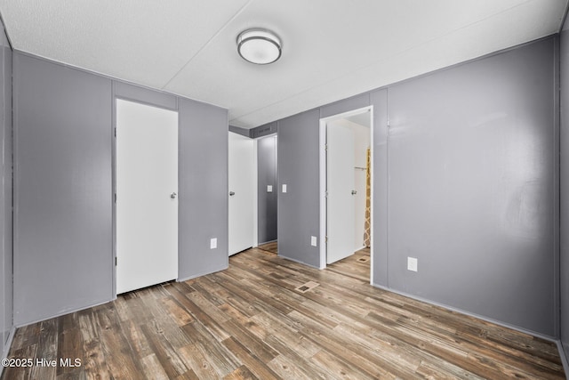 unfurnished bedroom featuring visible vents and wood finished floors