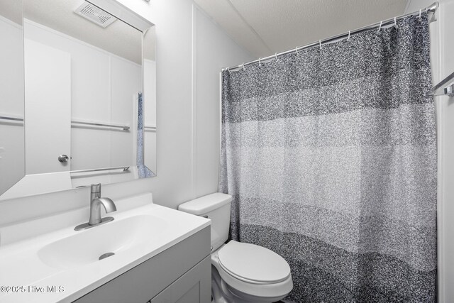 bathroom with visible vents, toilet, and vanity