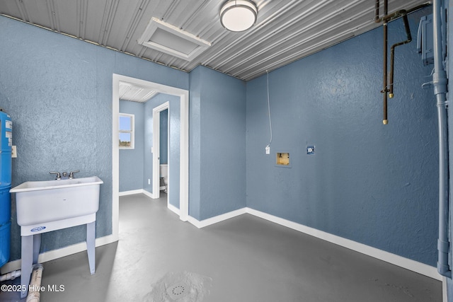 below grade area with a sink and a textured wall