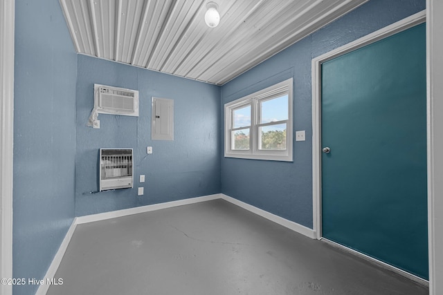 interior space with concrete flooring, an AC wall unit, baseboards, heating unit, and electric panel