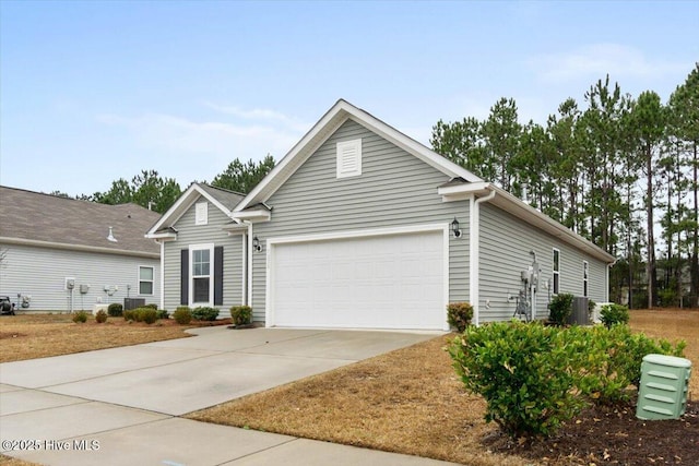 view of front of home featuring driveway, central air condition unit, and a garage