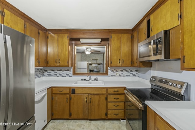 kitchen featuring appliances with stainless steel finishes, ceiling fan, sink, and backsplash