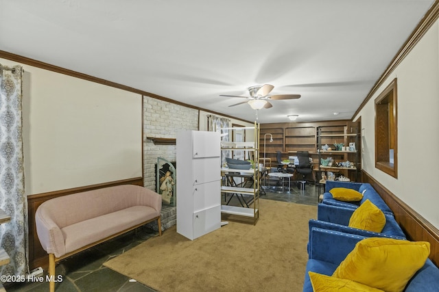 sitting room featuring carpet flooring, ceiling fan, ornamental molding, and a fireplace