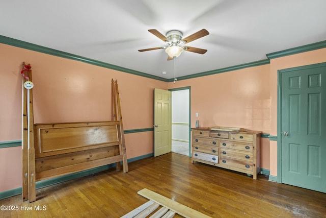 unfurnished bedroom featuring ceiling fan, dark wood-type flooring, and ornamental molding