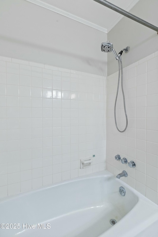 bathroom with ornamental molding and tub / shower combination