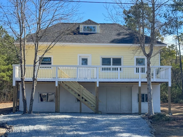 view of front of home featuring stairs and roof with shingles