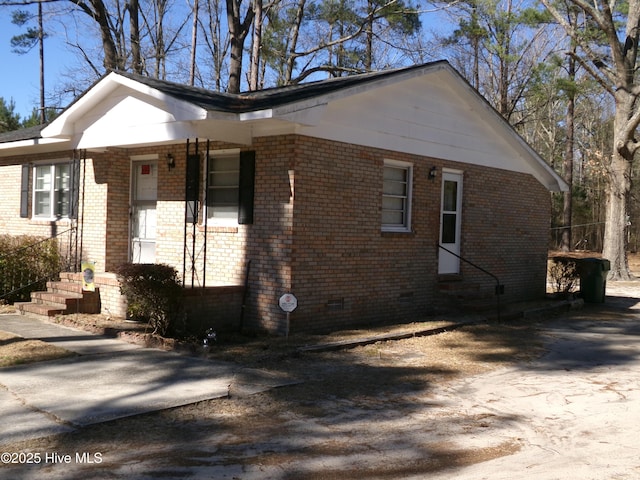 view of front of property featuring entry steps, brick siding, and crawl space