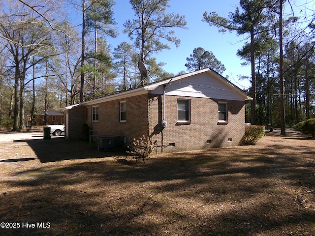 view of property exterior with crawl space, brick siding, a yard, and central AC