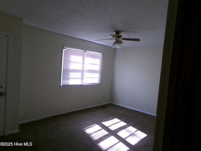 empty room featuring a ceiling fan, carpet flooring, a textured ceiling, and baseboards