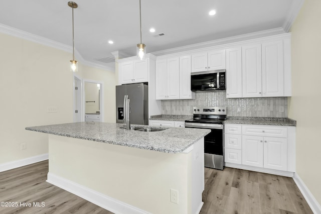 kitchen with sink, pendant lighting, stainless steel appliances, white cabinets, and a kitchen island with sink