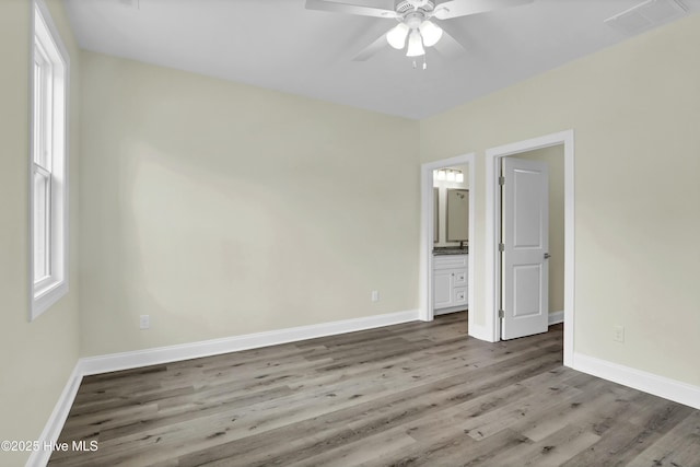 unfurnished bedroom featuring hardwood / wood-style floors, ceiling fan, and ensuite bath