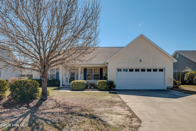 view of front of house featuring concrete driveway, an attached garage, and fence