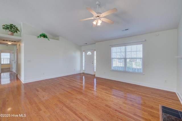 unfurnished living room featuring vaulted ceiling, light wood-type flooring, visible vents, and baseboards