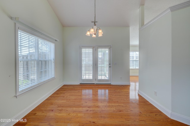 spare room featuring a chandelier, visible vents, light wood-style flooring, and baseboards