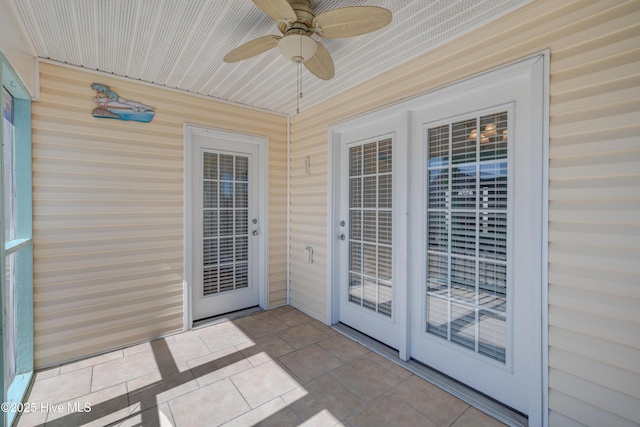 unfurnished sunroom featuring a ceiling fan