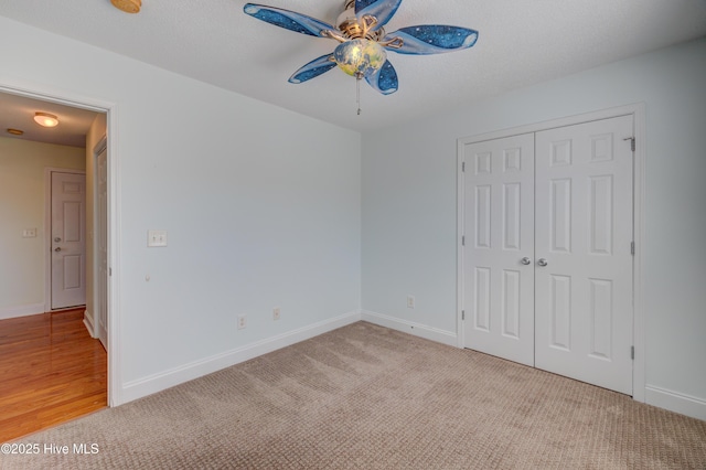 unfurnished bedroom featuring carpet floors, ceiling fan, baseboards, and a closet