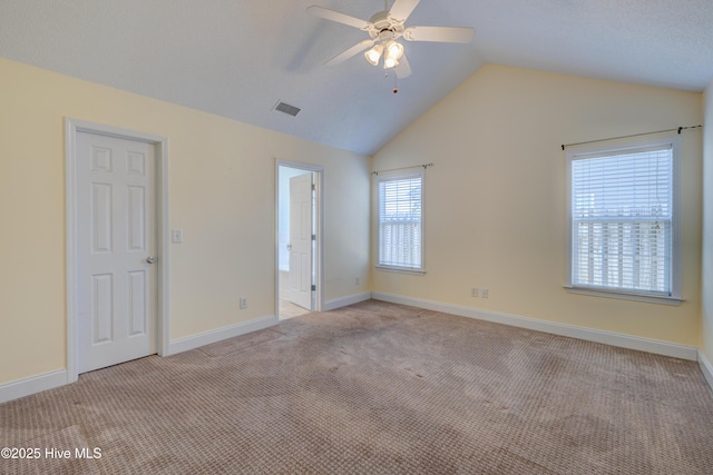 unfurnished room with light carpet, baseboards, visible vents, lofted ceiling, and ceiling fan