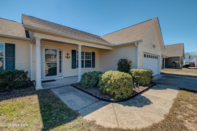 view of front facade featuring an attached garage, driveway, a shingled roof, and a porch