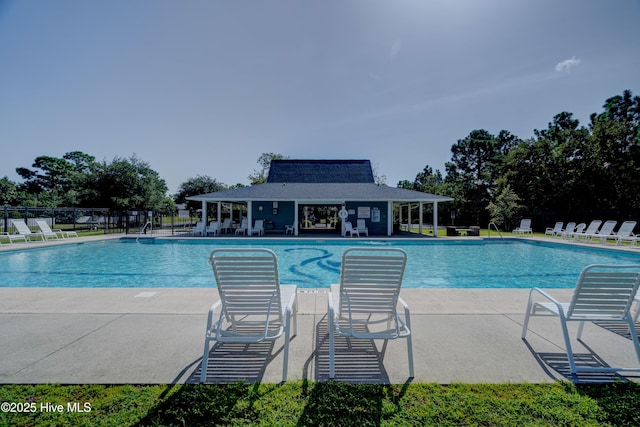 community pool with a patio area and fence