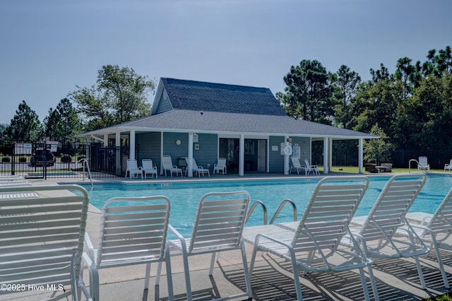 community pool with a patio area and fence