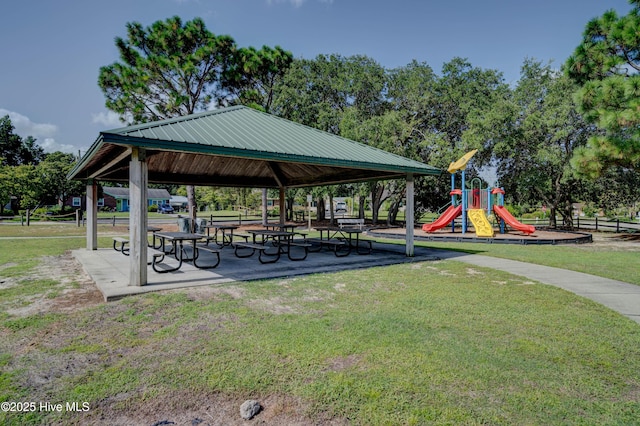 view of community featuring playground community, a lawn, and a gazebo