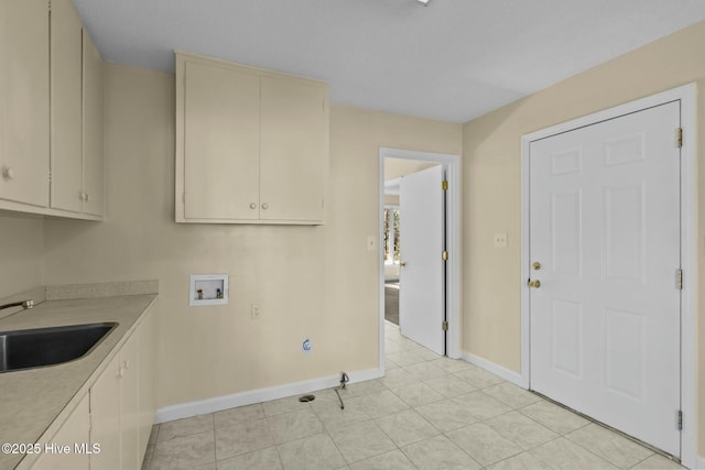 laundry room featuring hookup for a washing machine, cabinet space, light tile patterned flooring, a sink, and baseboards