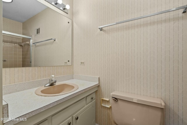 full bath featuring toilet, visible vents, walk in shower, and vanity