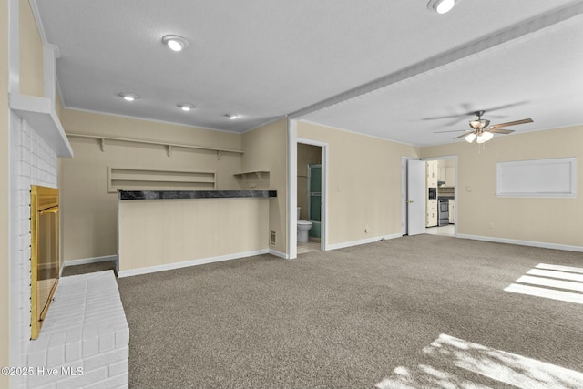 unfurnished living room with carpet floors, baseboards, and a ceiling fan