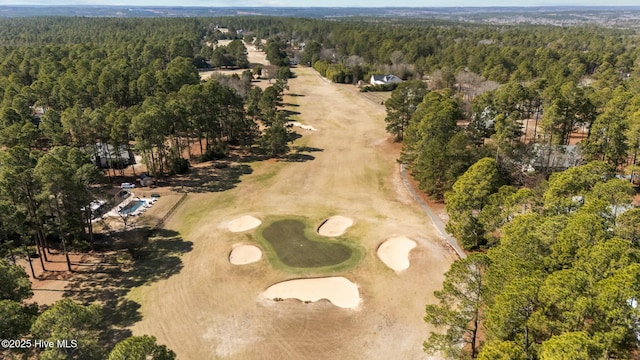 birds eye view of property featuring view of golf course and a wooded view