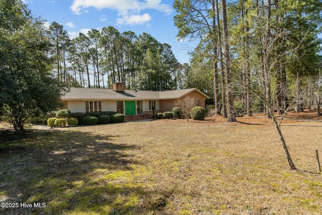 view of front of home featuring a chimney and a front lawn