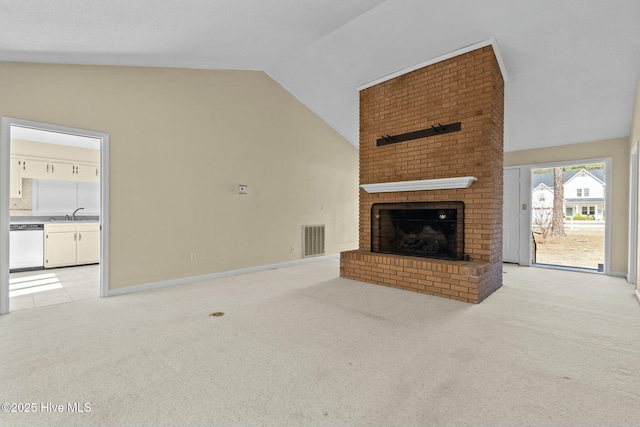 unfurnished living room featuring light carpet, a fireplace, a sink, visible vents, and vaulted ceiling