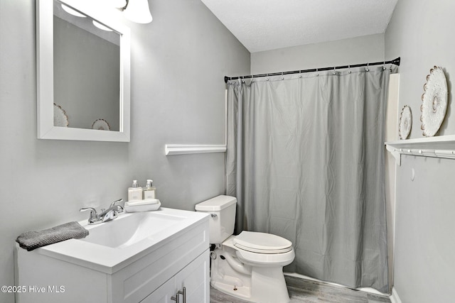 bathroom featuring a shower with shower curtain, toilet, wood finished floors, a textured ceiling, and vanity