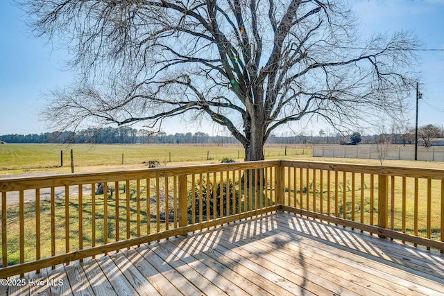 deck featuring a rural view and a lawn