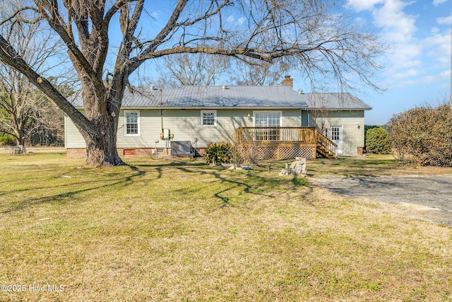 back of property with a chimney, a lawn, crawl space, a deck, and stairs