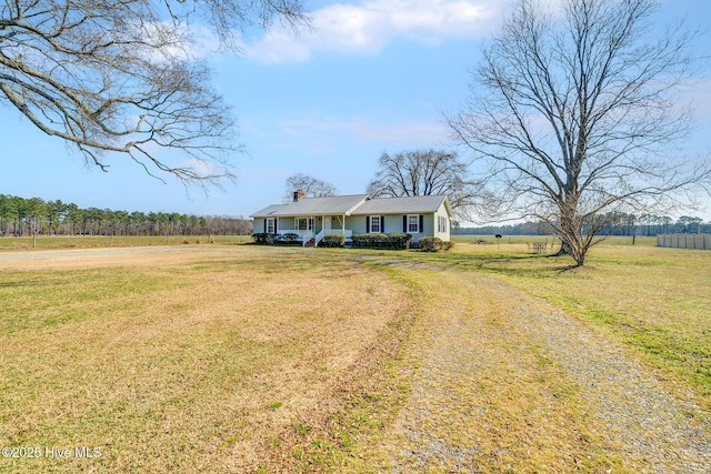 view of front of home with covered porch, a rural view, driveway, and a front lawn