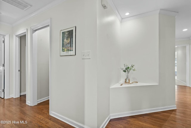 hall with visible vents, crown molding, and wood finished floors